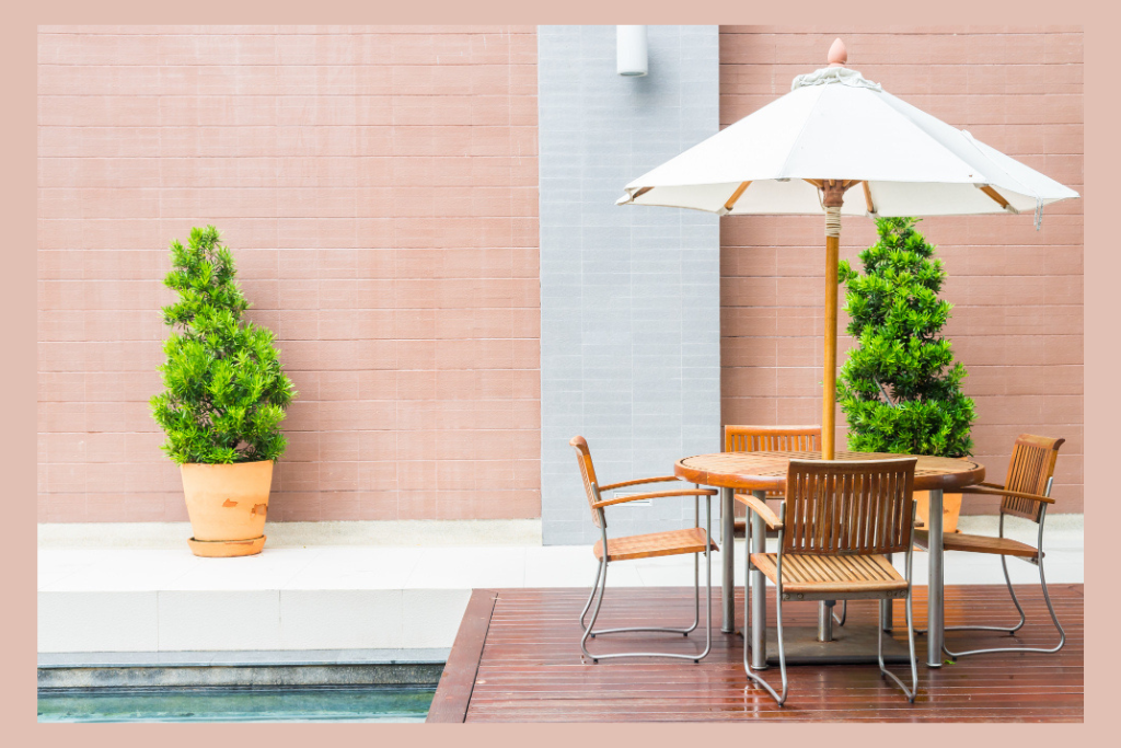 Modern patio renovation by a home improvement company in PA, featuring stylish outdoor furniture, potted plants, and a sunshade umbrella – perfect for homes in Mount Pleasant, PA.